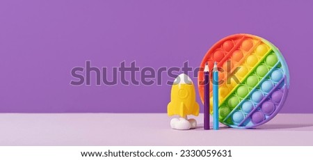 Colored pop it pad with rocket pencils on lilac purple background with rocket. stationery with copy space for back to school or education and craft concept. Bright minimal. Success achievement ideas Royalty-Free Stock Photo #2330059631