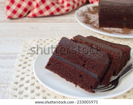 Chocolate cake on a plate on a wooden table.
