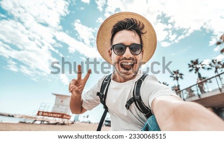 Happy young man taking selfie pic with smart mobile phone device outside - Smiling male tourist laughing at camera on summertime vacation - Summer holidays and modern technology life style concept