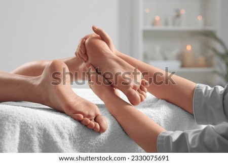 Woman receiving foot massage in spa salon, closeup
