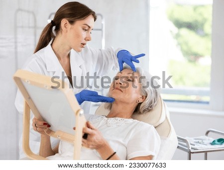 Doctor dermatologist and patient make advice before treatment or facelift in the consulting room Royalty-Free Stock Photo #2330077633