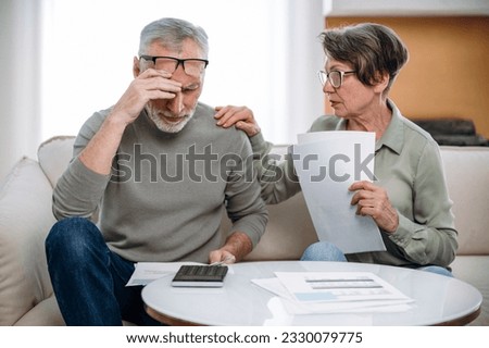 Stressed retired wife and husband manage family finances. Feeling desperate due debts, unpaid bills, lack of money to pay monthly loan or bank mortgage. Financial crisis, bankruptcy concept Royalty-Free Stock Photo #2330079775