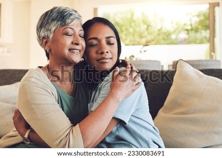 Family, senior woman hugging her daughter and love with people sitting on a sofa in the home living room during a visit. Smile, trust or comfort with an elderly female parent embracing an adult child