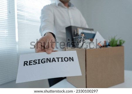Stressful businessmen will resign from the company. He is lifting a brown paper box that holds personal items. resignation, job placement and vacancies concept.
 Royalty-Free Stock Photo #2330100297