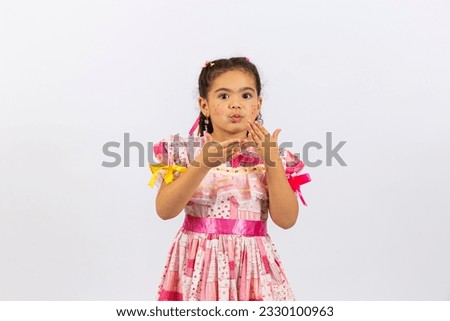 Beautiful little girl with typical June party clothes blowing kisses to the camera