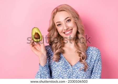 Photo of smiling charming young woman wear blue flowers daisy print dress hold ripe avocado healthy food isolated on pink color background
