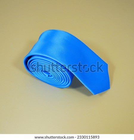 blue colour polyester fabric necktie rolled isolated on plain background close up shot single object concept nobody 