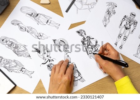 An artist draws characters for computer games. Illustrator drawing sketches on paper. Animation design studio. Animator designer. 