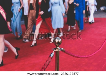 Red carpet with ropes and golden barriers on a luxury party entrance, cinema premiere film festival event award gala ceremony, wealthy rich guests arriving, outdoor decoration elements, summer day Royalty-Free Stock Photo #2330137577