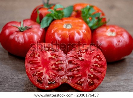 Isolated tomato Whole, half, tomato on dark wooden background. Tomatoes with green basil leaves. Clipping path. Full depth of field.