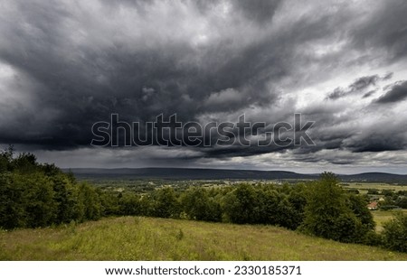 Thunderstorm over meadows and large cumulonimbus thundercloud and rain
