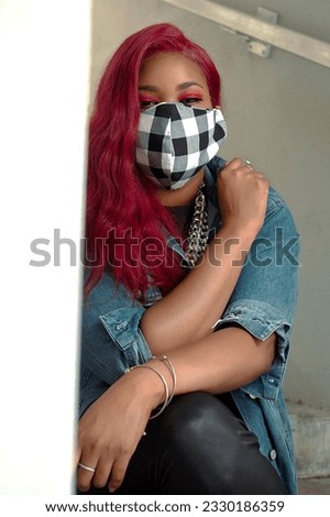 A beautiful plus size model rocking a punks style look outdoors with a mask covering her face.