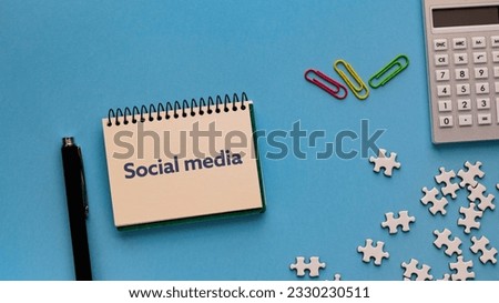 There is notebook with the word Social media. It is as an eye-catching image.