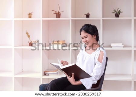 Asian woman holding and Reading Book. Female Enjoying Reading a Book