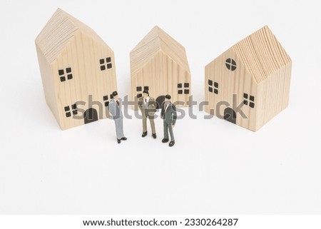 Three miniature businessman standing in front of wooden house for discuss about real estate investment, financial, purchase a new house. savings, economy, business, investment, loan, mortgage concept.