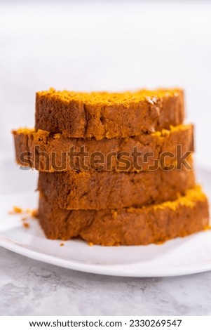 Stack of homemade pumpkin bread slices on a white plate. Royalty-Free Stock Photo #2330269547