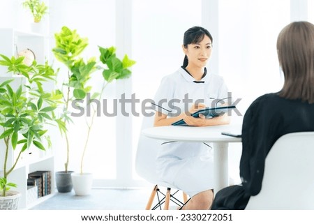 Female medical worker interviewing a patient in medical facility. Nursing. Therapist. Royalty-Free Stock Photo #2330272051