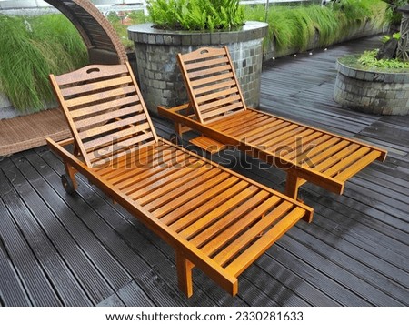 A brown lounge chair made from teak wood which is usually used at the beach, swimming or spa. Royalty-Free Stock Photo #2330281633
