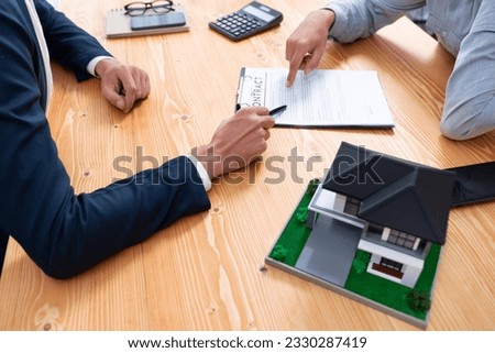 Client and real estate agent review loan contract, discussing term, interest rate, and property ownership. Analyze legal document and thoroughly read agreement before making decision. Entity Royalty-Free Stock Photo #2330287419