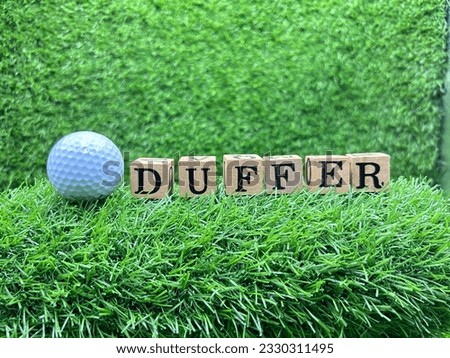 Golf Duffer is on green grass,  slang term within golf for a mediocre or poor golfer. 