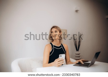 Photo of adorable young lady hold telephone look screen palm keyboard wear glasses shirt in home office indoors.