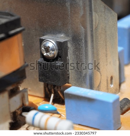 A MOSFET transistor mounted to the heatsink on the electronic circuit board. Royalty-Free Stock Photo #2330345797