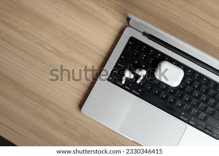 white wireless headphones lie on a laptop