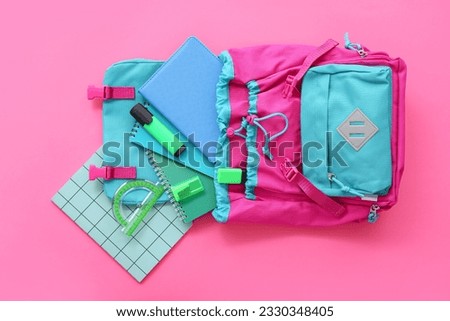 Color school backpack with notebooks, protractor and markers on pink background