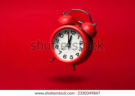 Red classic alarm clock on the red background