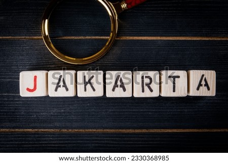 JAKARTA. Text from alphabet blocks on a dark wooden background.