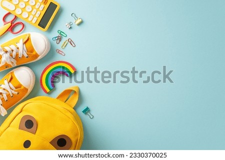 Growing curious minds. Creative top view of a cute children's backpack filled with lively school essentials and sneakers on a pastel blue backdrop, perfect for text or promotional content Royalty-Free Stock Photo #2330370025