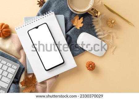 Experience coziness of freelance work in autumn with this top view picture featuring phone on notepad with pen and keyboard, hot cacao with cozy scarf on beige isolated background with copyspace