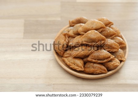 Thai snack ,Pun sib dried in a bowl on wooden background, (Thai Traditional Dessert) Royalty-Free Stock Photo #2330379239
