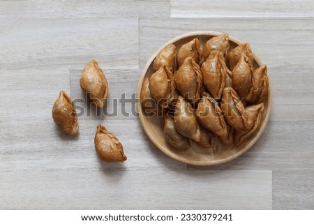 Thai snack ,Pun sib dried in a bowl on wooden background, (Thai Traditional Dessert) Royalty-Free Stock Photo #2330379241