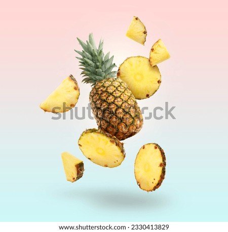 Fresh whole and cut pineapples falling on colorful background Royalty-Free Stock Photo #2330413829