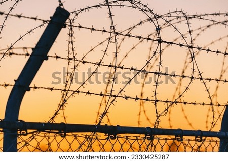Sunset sky and barbed wire Royalty-Free Stock Photo #2330425287