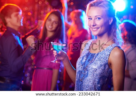 Stylish woman with martini glass posing at nightclub