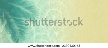 Tropical sand beach and sea wave ripple with coconut palm shadow from above. Top view of water surface background. Summer holiday and travel template backdrop.