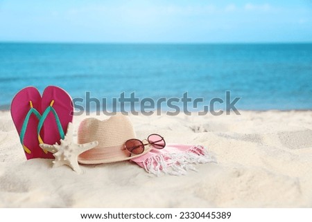 Accessories on sunny ocean beach, space for text. Summer vacation Royalty-Free Stock Photo #2330445389