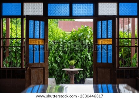 Stained glass of various colors is used to embellish the walls, doors, and windows of the old wooden house Royalty-Free Stock Photo #2330446317