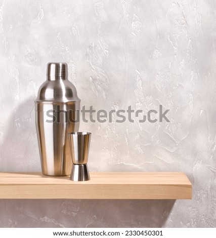 Shiny metal shaker and jigger on a gray background. Preparing alcoholic tasty cocktails at holiday parties, in the club. Copy space for text.