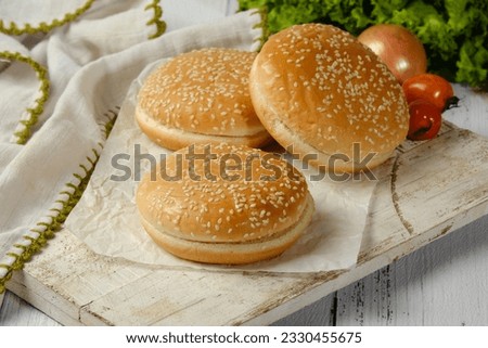 freshly baked plain golden brown hamburger buns topped with sesame seeds