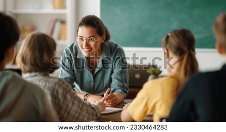 Happy kids and teacher at school. Woman and children are talking in the class. Royalty-Free Stock Photo #2330464283