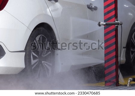 Technology, Automatic car wash machine in action. Car going through an automated wash. High-pressure water spray in the wash machine. Dotted with soap suds. Tunnel Wash Automatic Car. 