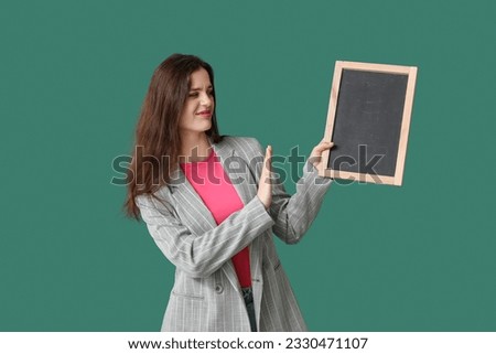 Female teacher rejecting chalkboard on green background