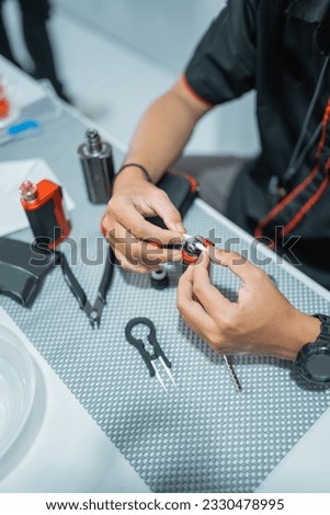 close up of male shopkeeper changing the vape cotton coil at the vape store