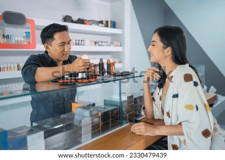 male vape seller helping the female customer to refill the e liquid at vape store