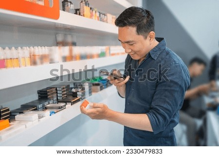 male vape seller taking photo of the liquid stock for online shop