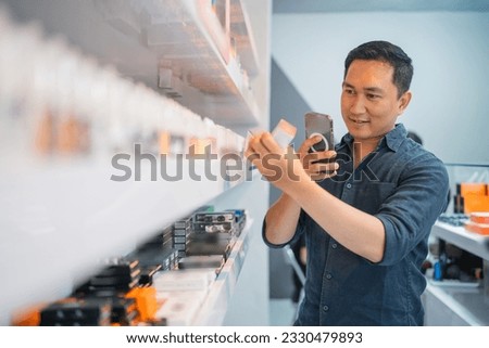 asian shopkeeper taking photo of the liquid at vape store for online shop