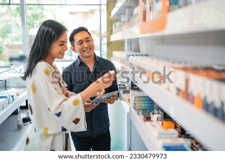 couple of vape seller checking the stock of the liquid using the digital tablet